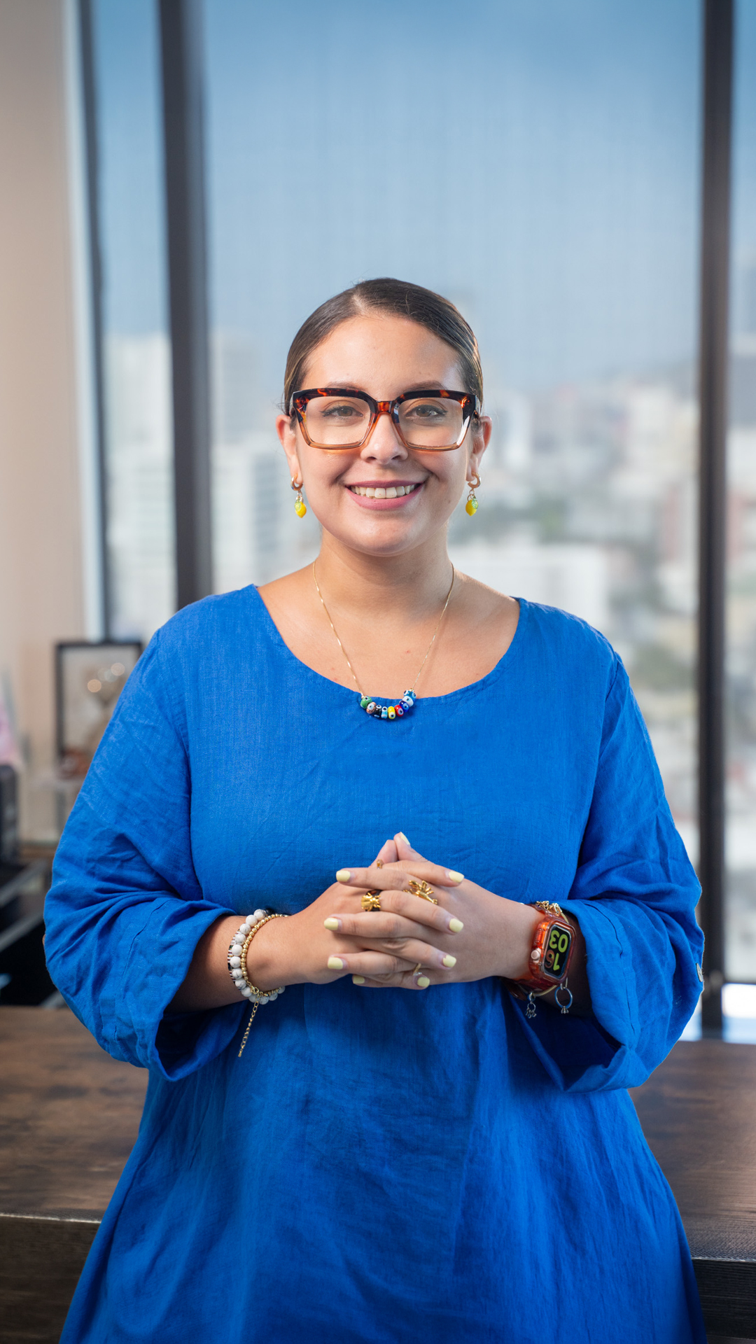 Dra. Carolina Garza sonriendo, con lentes y vestido azul.